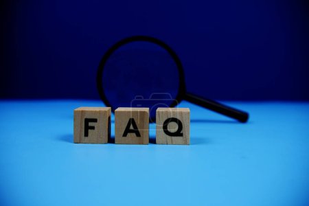 Photo for FAQ with wooden blocks alphabet letters and Magnifying glass on blue background - Royalty Free Image