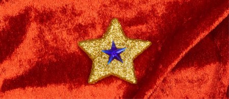 Photo for Blue star on gold star on red velvet - Royalty Free Image