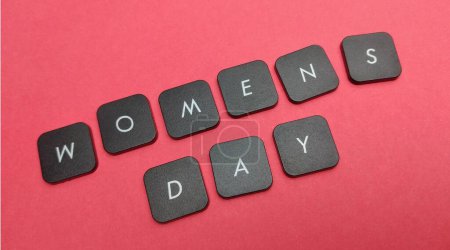 Wörter Frauentag aus schwarzen Tastaturtasten auf rotem Hintergrund.