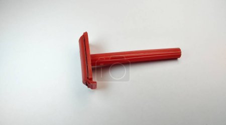 Rotes Rasiermesser aus Kunststoff auf weißem Hintergrund, Nahaufnahme eines Fotos