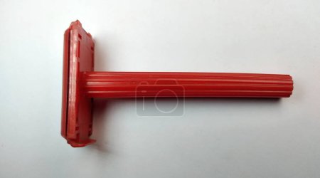 Rotes Rasiermesser aus Kunststoff auf weißem Hintergrund, Nahaufnahme eines Fotos