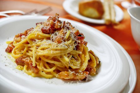 Detail des Tellers mit Spaghetti Carbonara auf gedecktem Tisch
