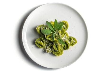 Top view of Dinner plate of green ravioli with sage and parmesan on white background