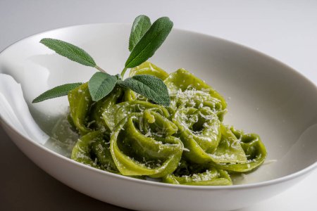 Pasta Bowl of green ravioli with sage and parmesan on white background