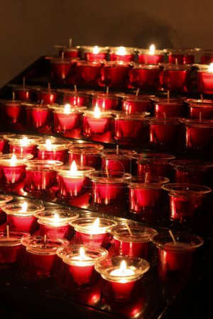 Photo for Closed Up Picture of Red Candles that is Lit Arranged Neatly - Royalty Free Image