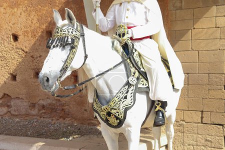 Téléchargez les photos : Une personne portant un costume de soldat marocain d'inspiration traditionnelle vintage chevauchant un cheval décoré - en image libre de droit