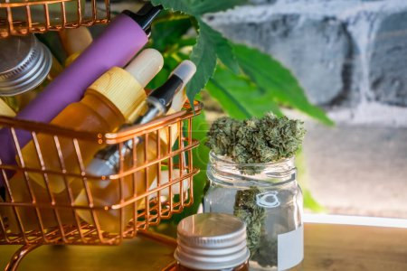 Mini carrito de compras con varios productos de cannabis medicinal en la mesa, concepto de compra de compras de suplementos de marihuana