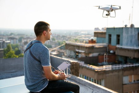Junger Techniker fliegt Drohne mit Fernbedienung