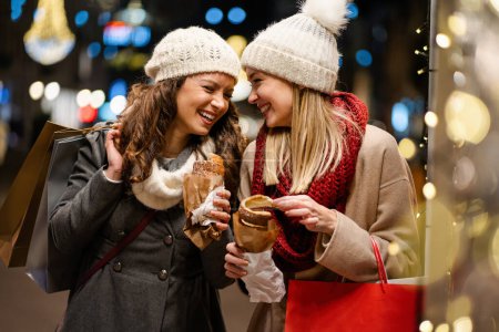 Téléchargez les photos : Portrait de jeunes femmes gaies et heureuses faisant des achats de Noël. Noël vente gens concept - en image libre de droit