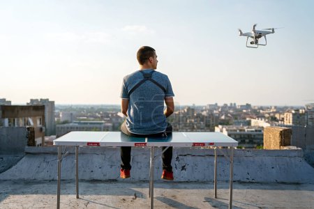 Photo for Young technician flying UAV drone with remote control outdoor - Royalty Free Image