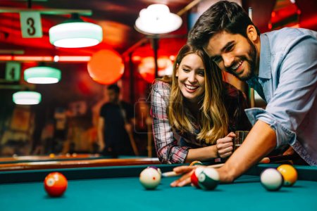 Photo for Couple dating, flirting and playing billiard in a pool hall - Royalty Free Image