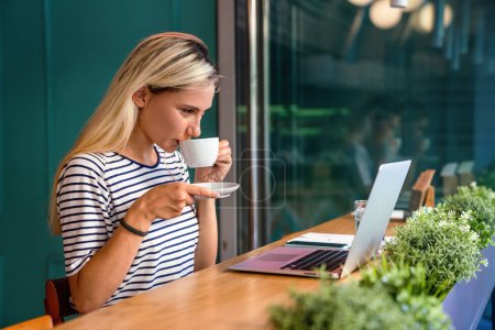 Téléchargez les photos : Portrait de belle femme travaillant sur ordinateur portable dans un café ou à la maison. Personnes business education digital device concept. - en image libre de droit