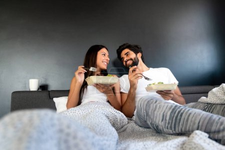 Téléchargez les photos : Couple heureux romantique prenant le petit déjeuner au lit. Amour, personnes, concept alimentaire - en image libre de droit