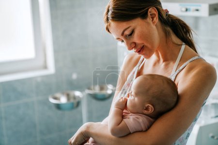 Foto de Retrato de la hermosa madre con su bebé en el fondo del hospital. Salud y familia médica amor concepto de estilo de vida - Imagen libre de derechos