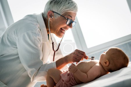 Foto de Feliz pediatra examina al bebé. Salud, examen médico, concepto de personas - Imagen libre de derechos