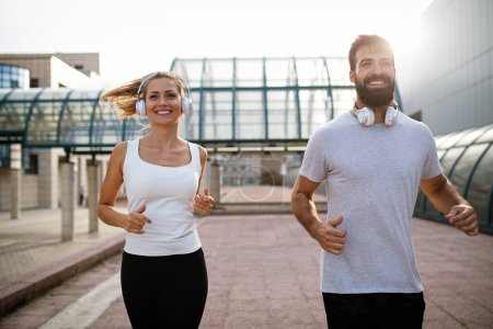 Téléchargez les photos : Fitness sport santé gens et mode de vie concept. Happy fit couple souriant courir à l'extérieur - en image libre de droit