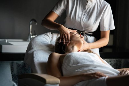 Téléchargez les photos : Femme relaxante ayant une massothérapie au salon de spa - en image libre de droit
