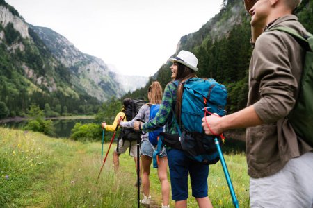 Foto de Grupo de amigos con mochilas haciendo excursión de trekking en la montaña. Trekker, deporte, senderismo y concepto de viaje - Imagen libre de derechos
