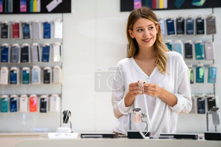 Téléchargez les photos : Portrait de femme souriante heureuse faisant du shopping une nouvelle montre intelligente dans un magasin de technologie. Technologie gens gadget dispositif concept - en image libre de droit