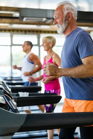 Foto de Hombre y mujer mayores en forma haciendo ejercicios en el gimnasio para mantenerse saludables. Gente concepto deportivo - Imagen libre de derechos