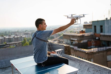Foto de Joven técnico hombre que vuela dron UAV con control remoto en la ciudad al aire libre - Imagen libre de derechos