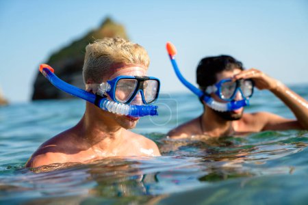 Foto de Amigos felices disfrutando de vacaciones de verano, viajes. Buceo, snorkel nadando en el mar transparente - Imagen libre de derechos