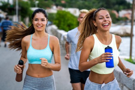 Foto de Grupo de amigos de fitness en forma alegre equipo de ejercicio juntos al aire libre. Gente deportiva fitness concepto de salud - Imagen libre de derechos