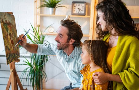 Photo for Happy family concept. Young smiling parents with children painting together at home. People fun happyiness. - Royalty Free Image