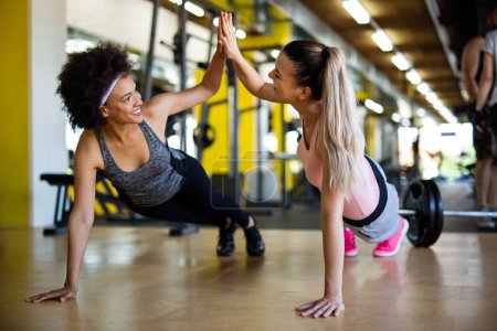 Photo for Beautiful fit young women, friends working out in gym together. Sport, people concept - Royalty Free Image