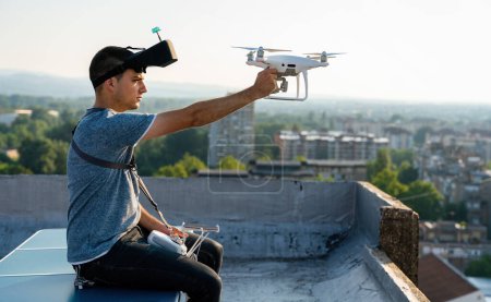 Foto de Joven técnico que vuela dron UAV con control remoto al aire libre - Imagen libre de derechos
