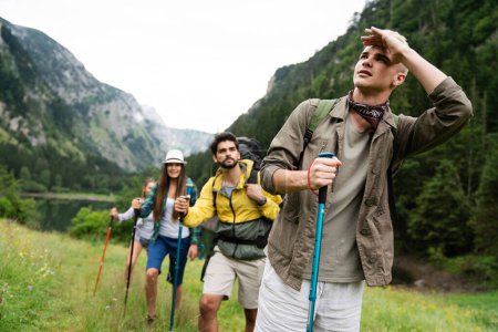 Foto de Grupo de amigos jóvenes en forma feliz senderismo, trekking juntos naturaleza al aire libre - Imagen libre de derechos