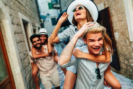 Foto de Feliz grupo de jóvenes amigos, estudiantes disfrutando de un recorrido turístico por la ciudad en vacaciones de verano. - Imagen libre de derechos