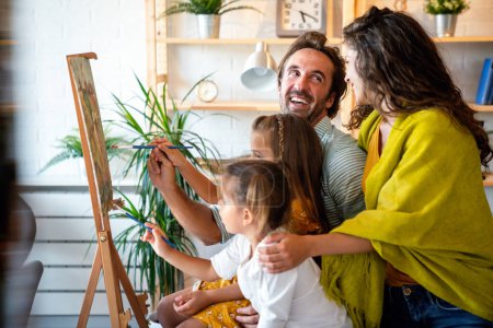 Photo for Happy family concept. Young smiling parents with children painting together at home. People fun happyiness. - Royalty Free Image
