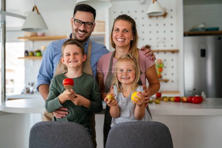 Photo for Happy family having fun preparing healthy food together in kitchen - Royalty Free Image