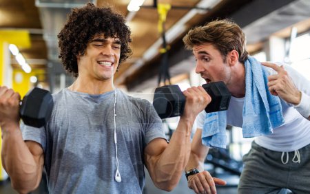 Photo for Fit young man working out in gym with personal trainer to stay healthy. Sport, people concept - Royalty Free Image