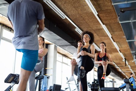 Photo for Group of sportive fit people working out in a gym. Multiracial friends exercising together in fitness club. - Royalty Free Image