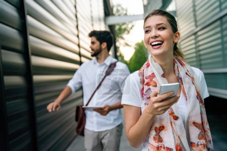 Téléchargez les photos : Homme d'affaires heureux et femme avec des appareils numériques à l'extérieur. Concept de bonheur des gens d'affaires - en image libre de droit