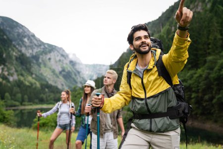 Photo for Hiking with friends is so fun. Group of young people with backpacks trekking together - Royalty Free Image