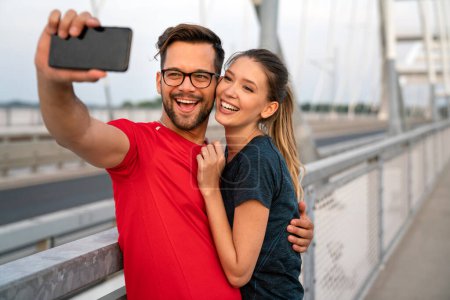 Photo for Fitness, sport, training, technology and lifestyle concept. Two smiling fit people with smartphones outdoors - Royalty Free Image