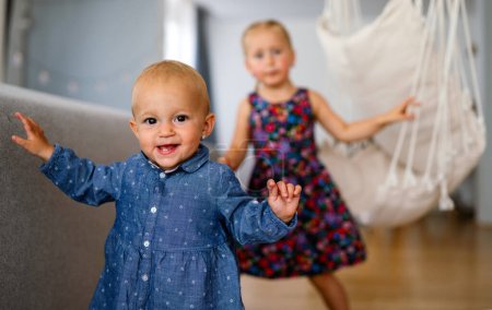 Foto de Retrato de dos niñas lindas niños jugando y divirtiéndose en la habitación de los niños. Familia, concepto de hermanos - Imagen libre de derechos