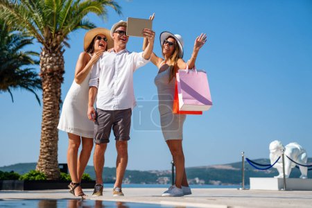 Photo for Vacation, travel, technology, smart phone, friendship and people concept. Smiling friends having fun, enjoying shopping - Royalty Free Image