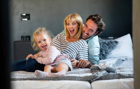Foto de Familia joven y feliz divirtiéndose en casa. La gente ama el concepto de hogar infantil. - Imagen libre de derechos