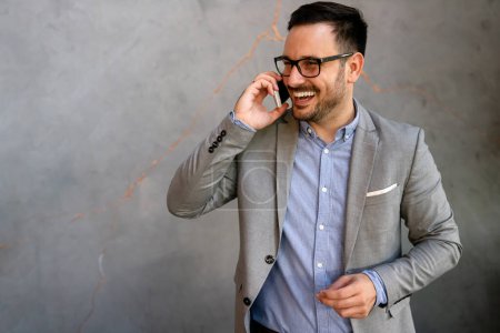 Téléchargez les photos : Portrait d'un homme d'affaires prospère parlant sur smartphone pendant une pause café dans un bureau d'entreprise - en image libre de droit