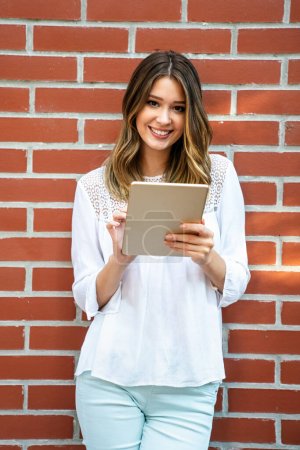 Photo for Beautiful young woman using digital tablet and smiling. People technology business concept. - Royalty Free Image
