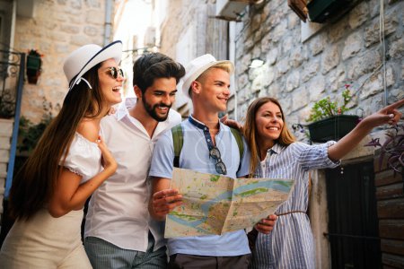 Happy traveling student tourists sightseeing with map in hand