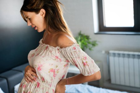 Foto de Mujer embarazada con dolores abdominales y de espalda en el último trimestre del embarazo - Imagen libre de derechos