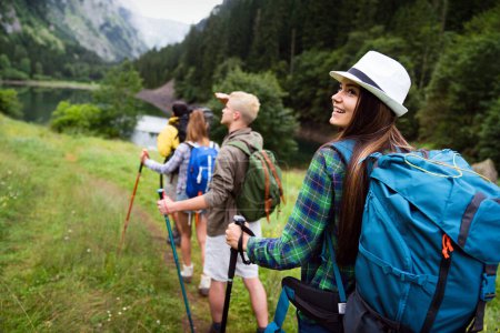 Téléchargez les photos : Heureux groupe d'amis randonneurs trekking dans le cadre d'un mode de vie sain en plein air activité - en image libre de droit