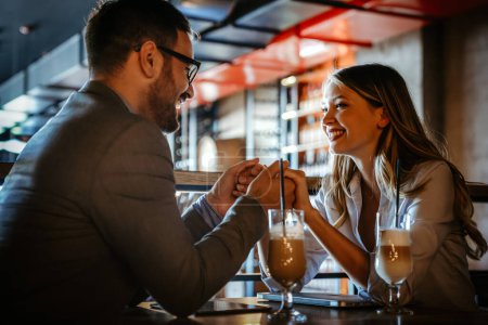 Foto de Romántica pareja joven y amorosa bebiendo café, teniendo una cita en el café. - Imagen libre de derechos