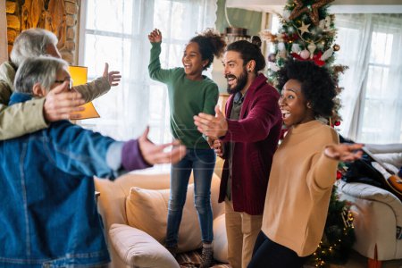 Photo for Excited multiethnic family greeting grandparents on Christmas Day. Multi-generational happy family, holiday concept. - Royalty Free Image