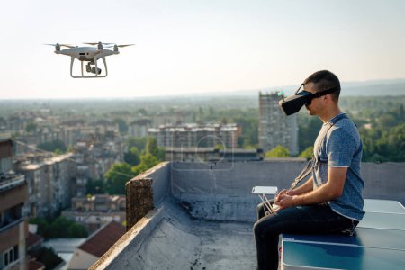 Téléchargez les photos : Jeune homme avec drone et téléspectateur de réalité virtuelle à l'extérieur. - en image libre de droit